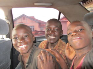 3 boys in the back of a car