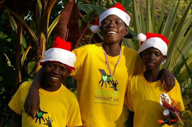 3 children smiling wearing Santa hats