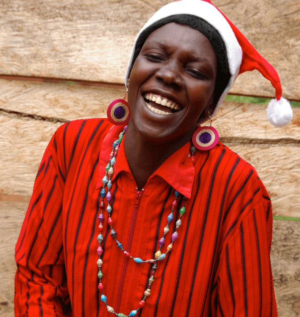 A lady smiling wearing a Santa hat