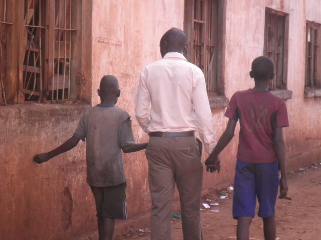 a worker walks on the street with 2 children