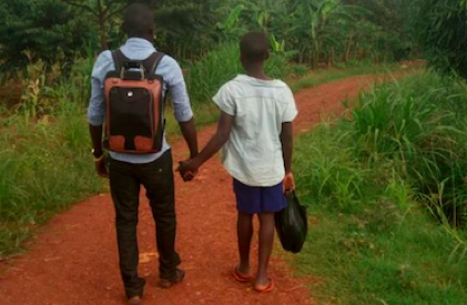 a volunteer and child holding hands