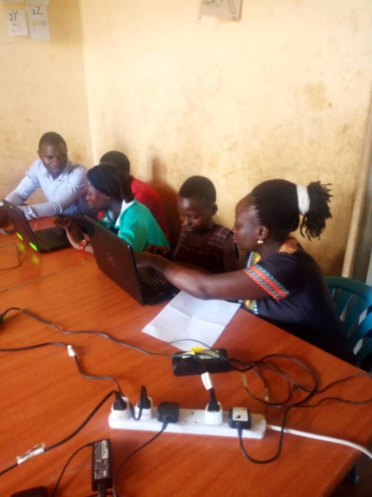 children on laptops in a classroom