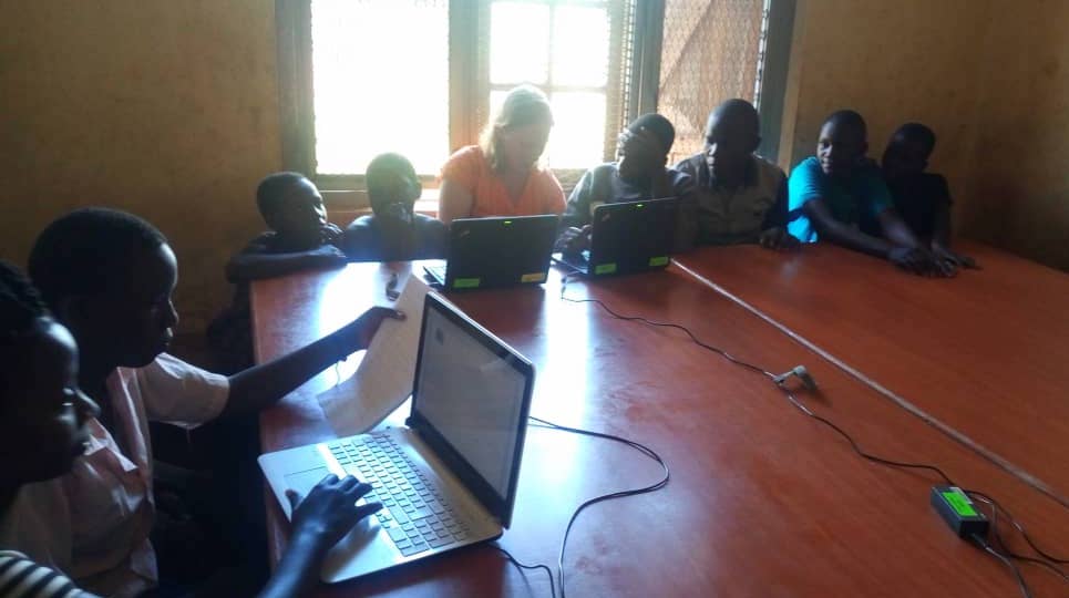 children on laptops in a classroom