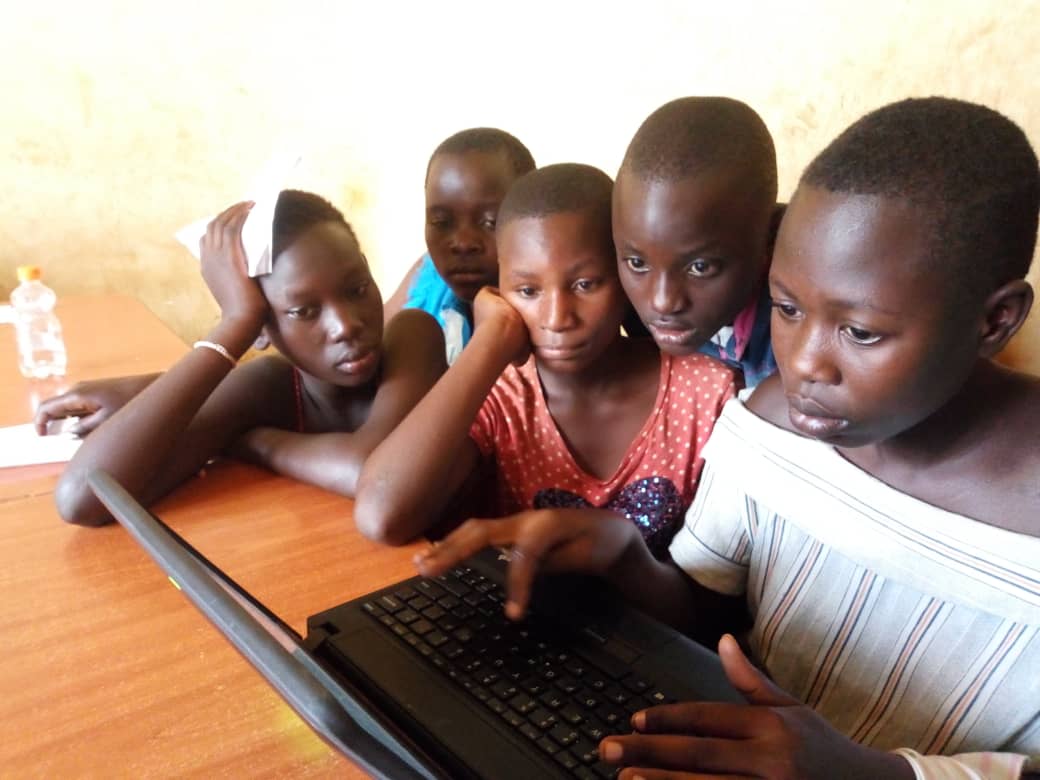 children on laptops in a classroom