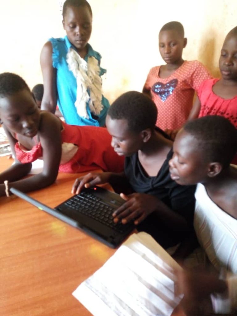 children on laptops in a classroom
