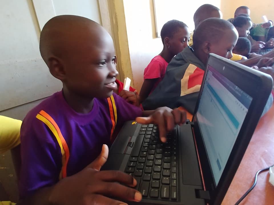 children on laptops in a classroom