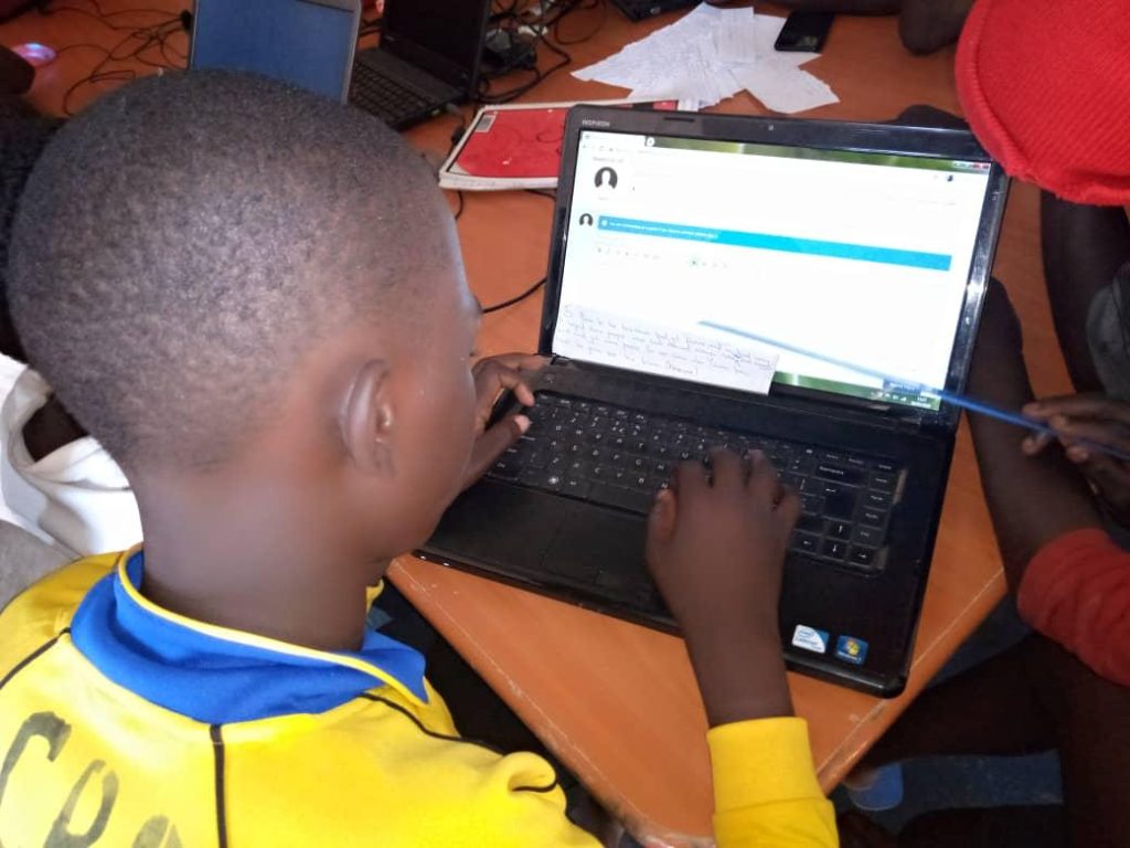 children on laptop in a classroom