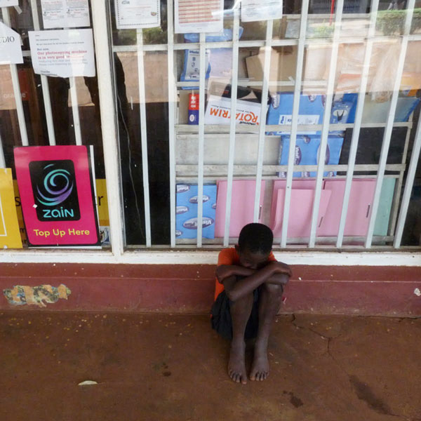 a child on the street outside a shop