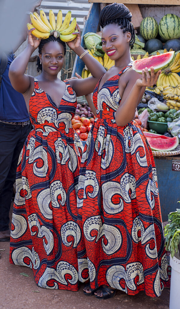 women in a market wearing traditional colourful Ugandan dresses