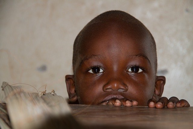 child peering over a table