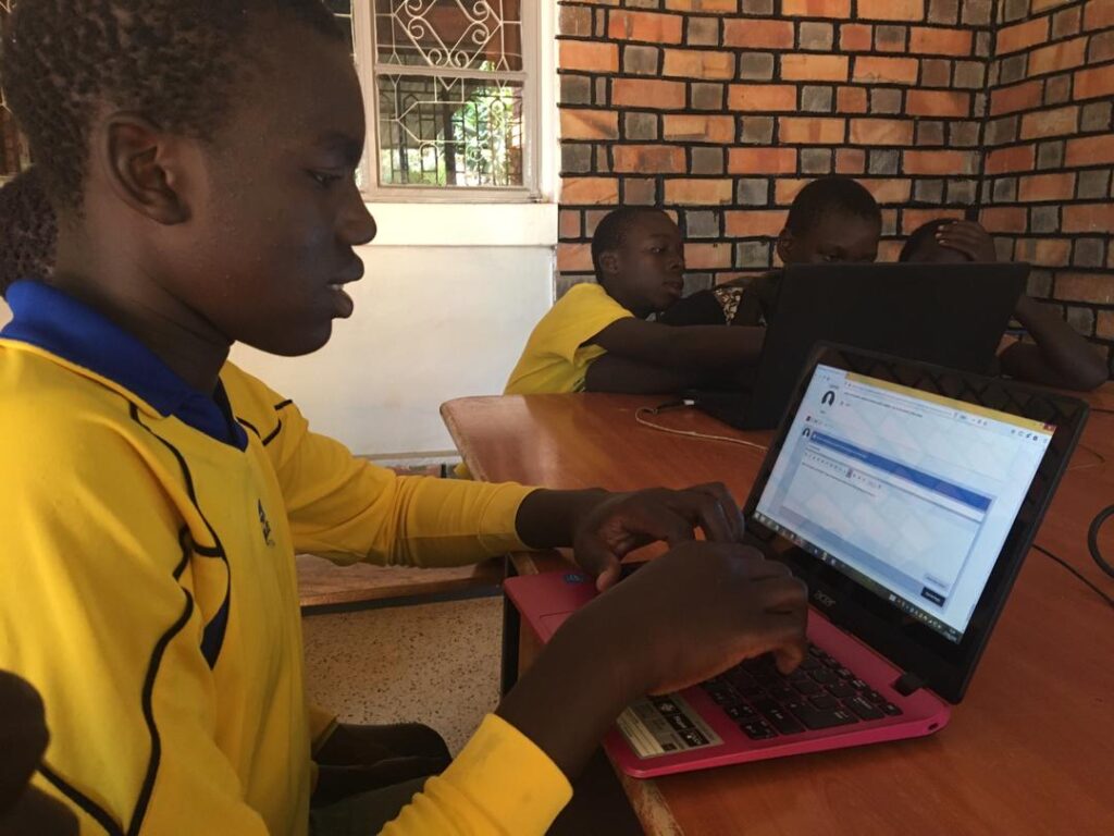 children on laptops in a classroom