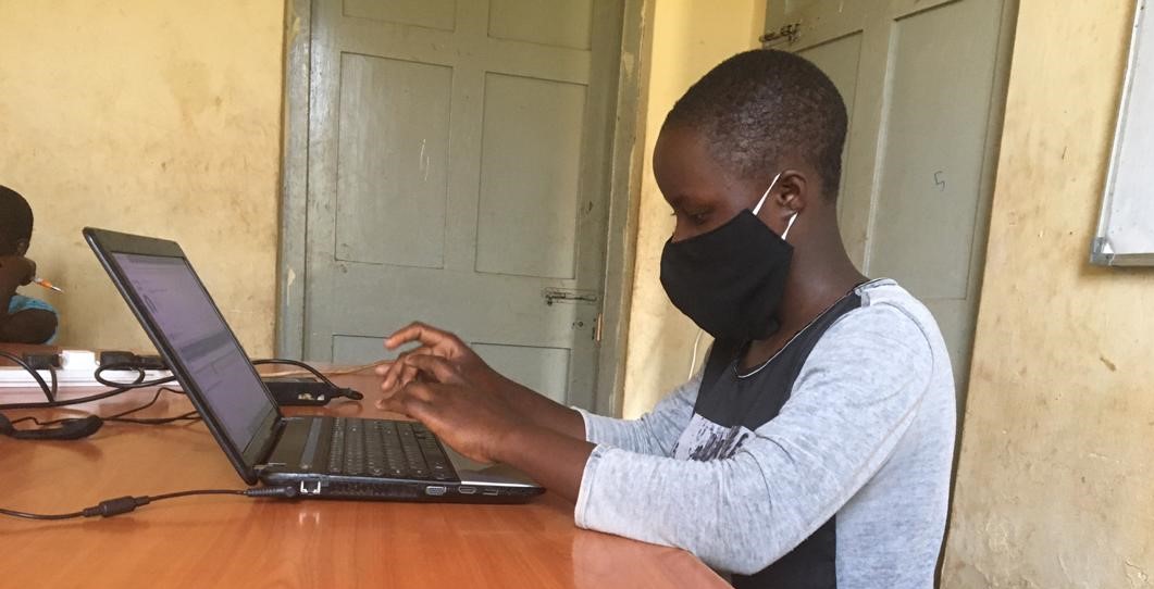 young boy working on computer in Uganda