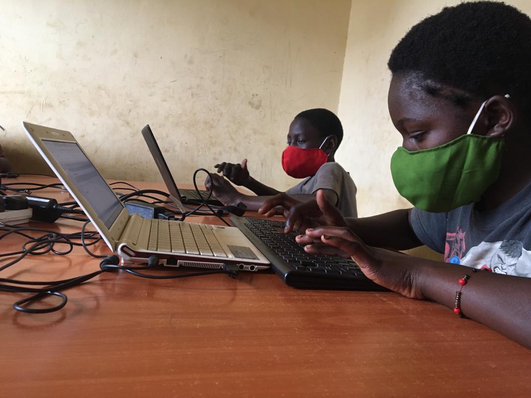 Young boys learning computer skills in Uganda