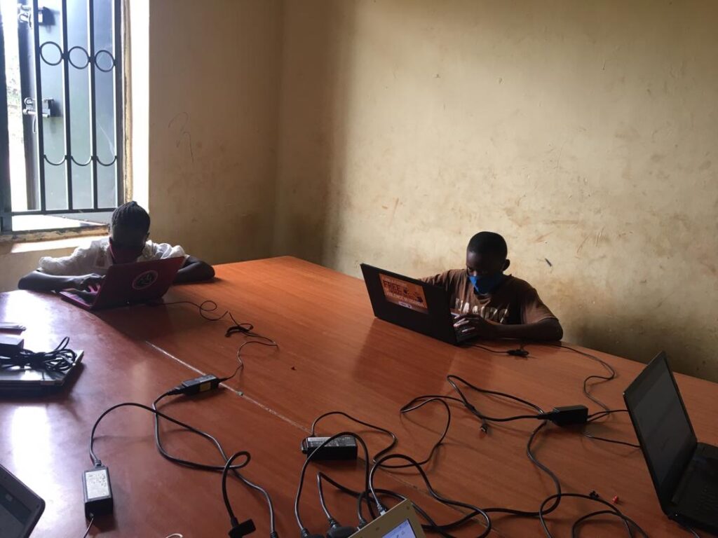 Children learning computer skills in Uganda