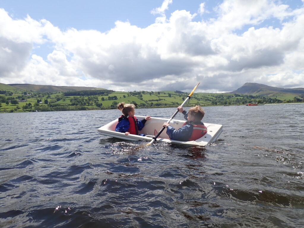children paddling on a lake in a bathtub