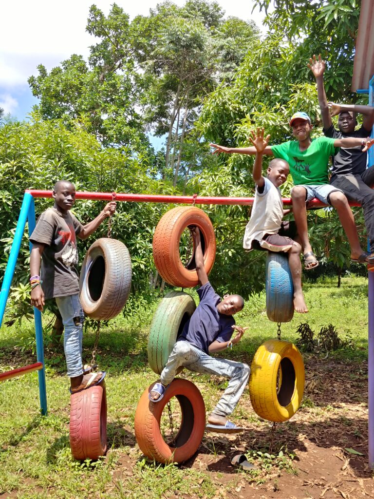 Children playing on a frame with tyres hanging from it