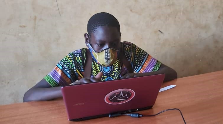 A child works on a laptop at a school