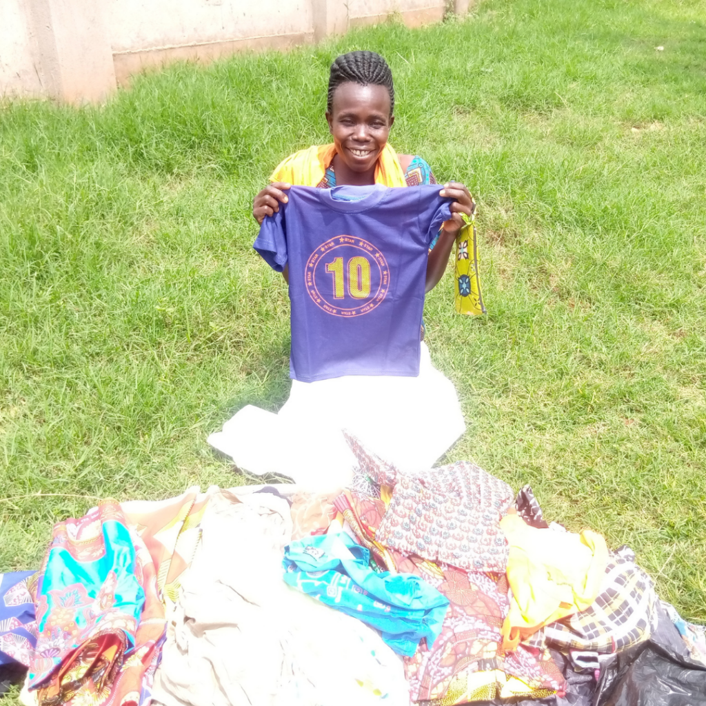 A woman holding up a t-shirt at a clothes stall