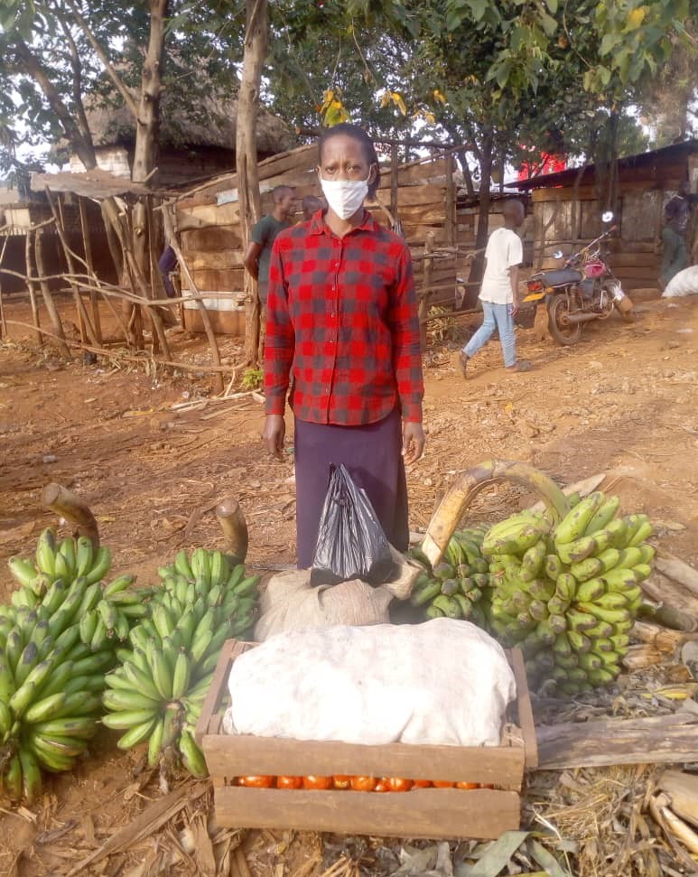 Patience standing near a pile of bananas