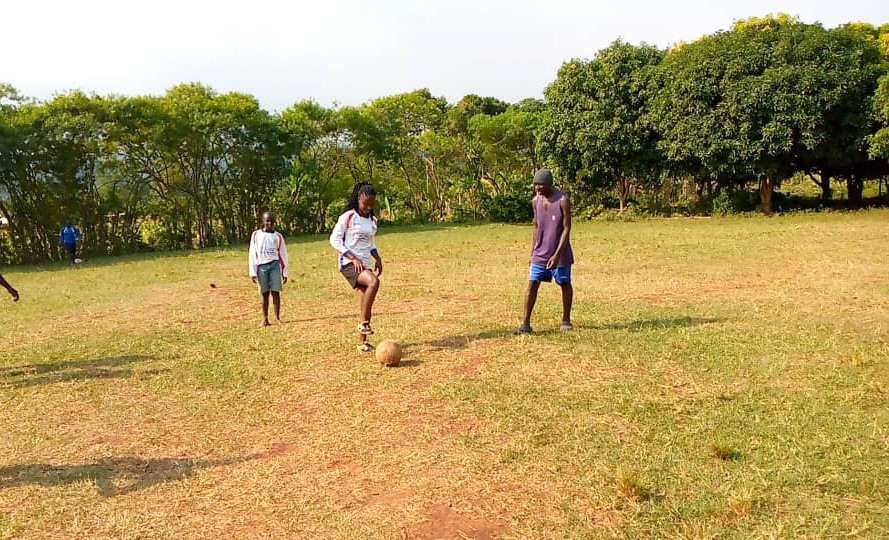 3 children are having fun playing with a football together