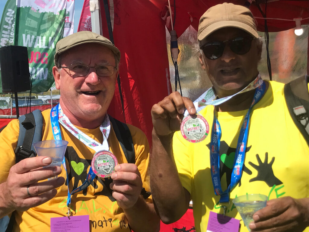Steve and Taresh holding up their Peak District Challenge medals