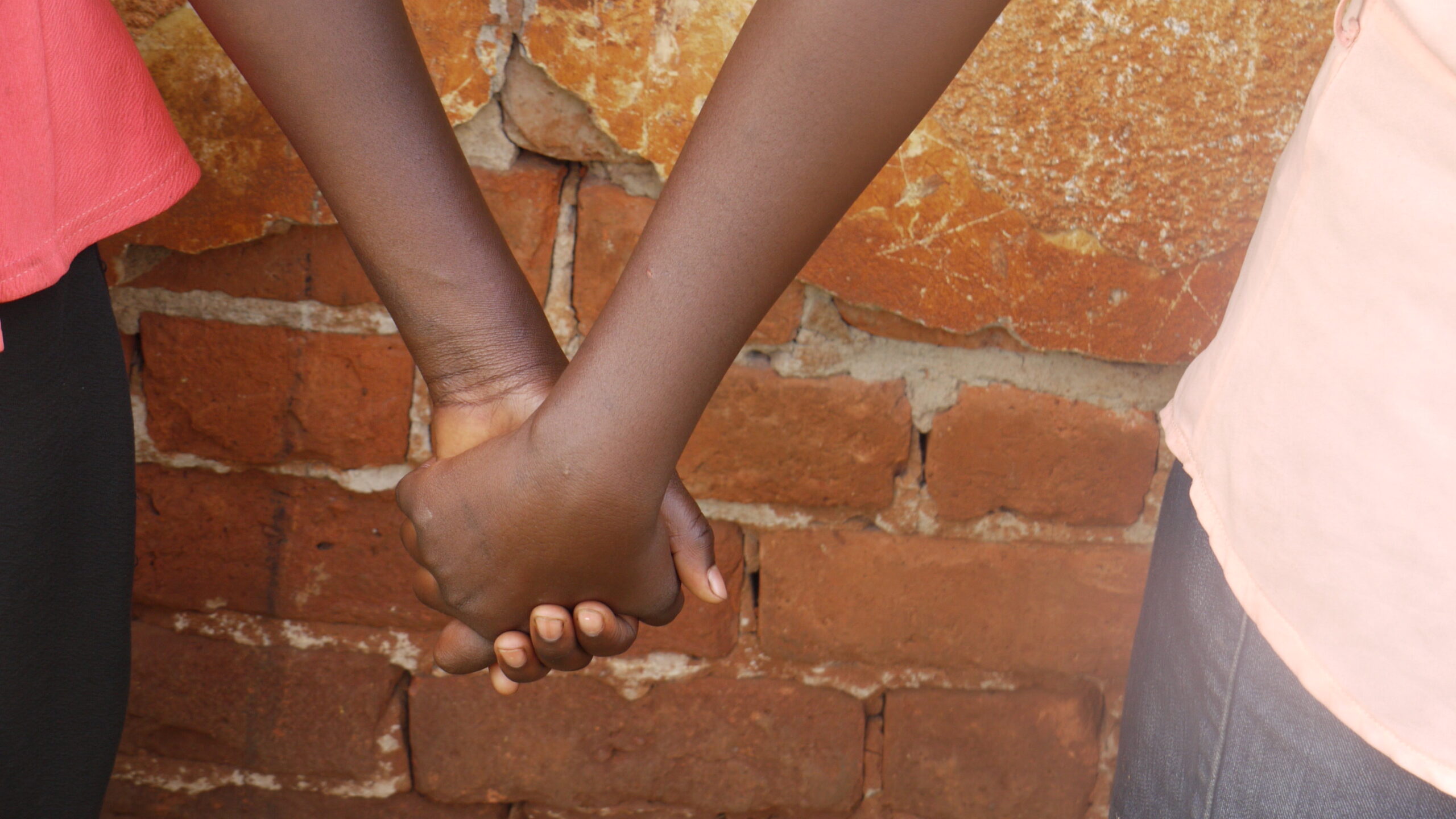 Two children's hands are clasped together