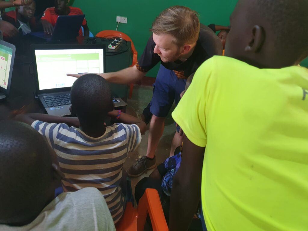 Children and volunteer looking at a computer screen