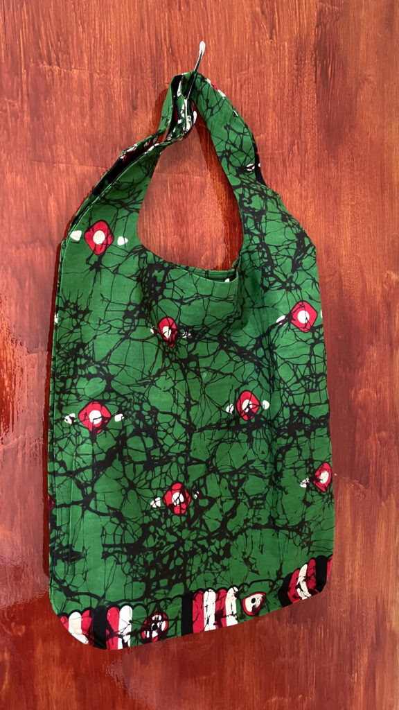 green shopping bag with red design and black details