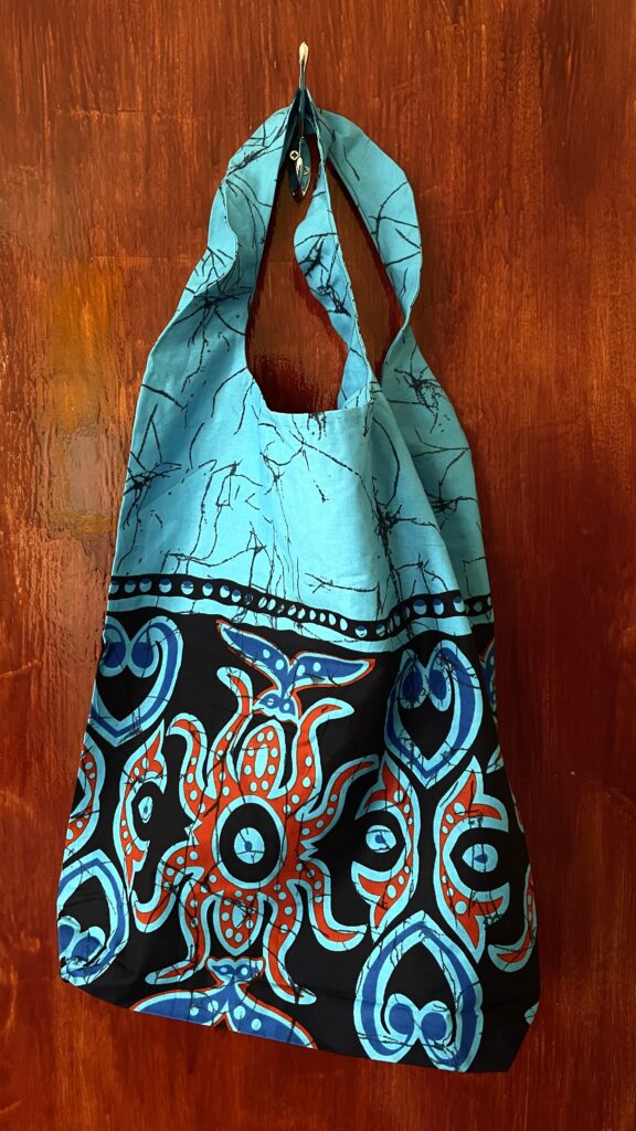 turquoise shopping bag with black, red and light blue designs