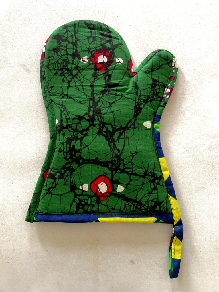 green oven glove with red and black design