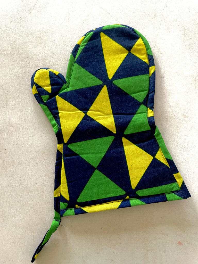 green, blue and yellow oven glove with geometric shapes