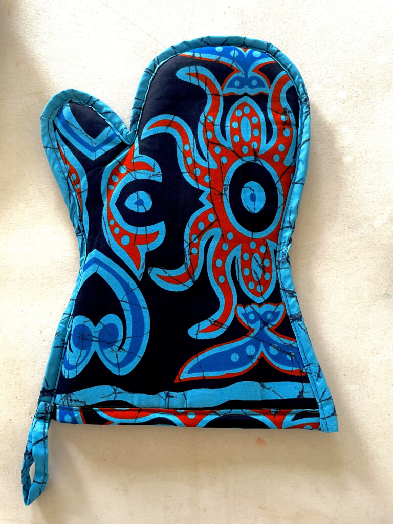 turquoise oven glove with red and light blue design