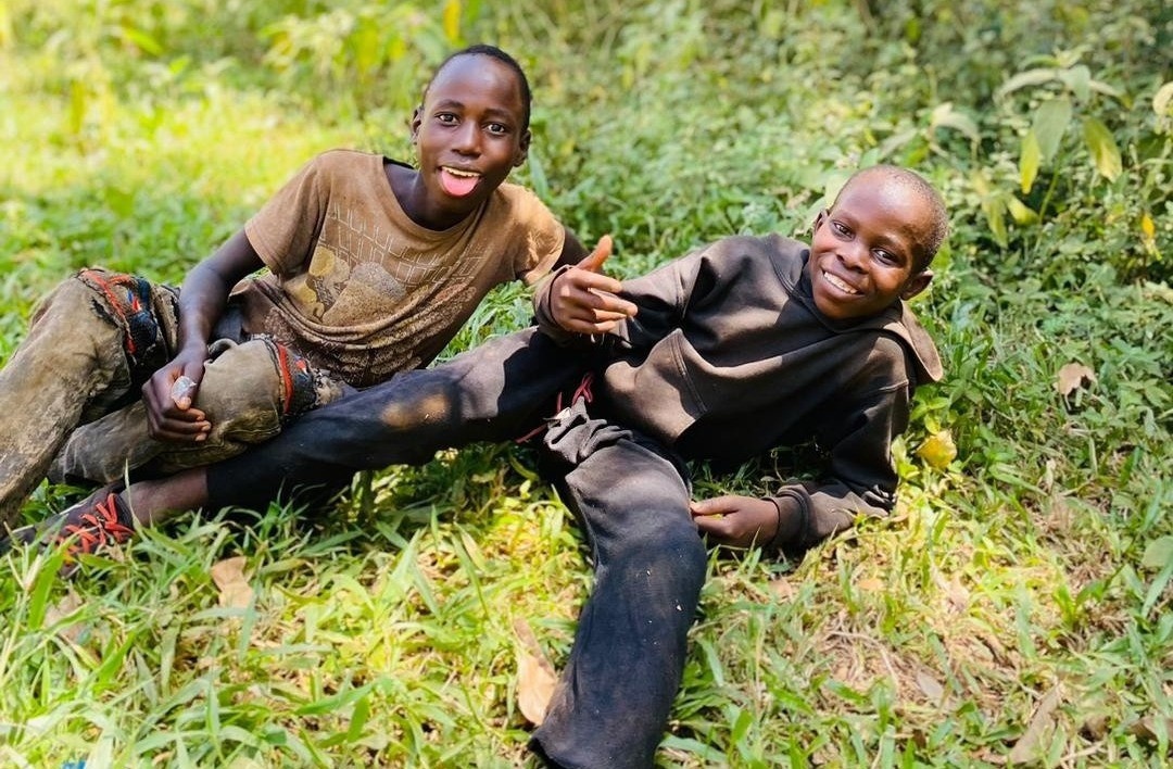 two boys lying on grass and smiling
