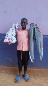 Boy smiling holding clothes