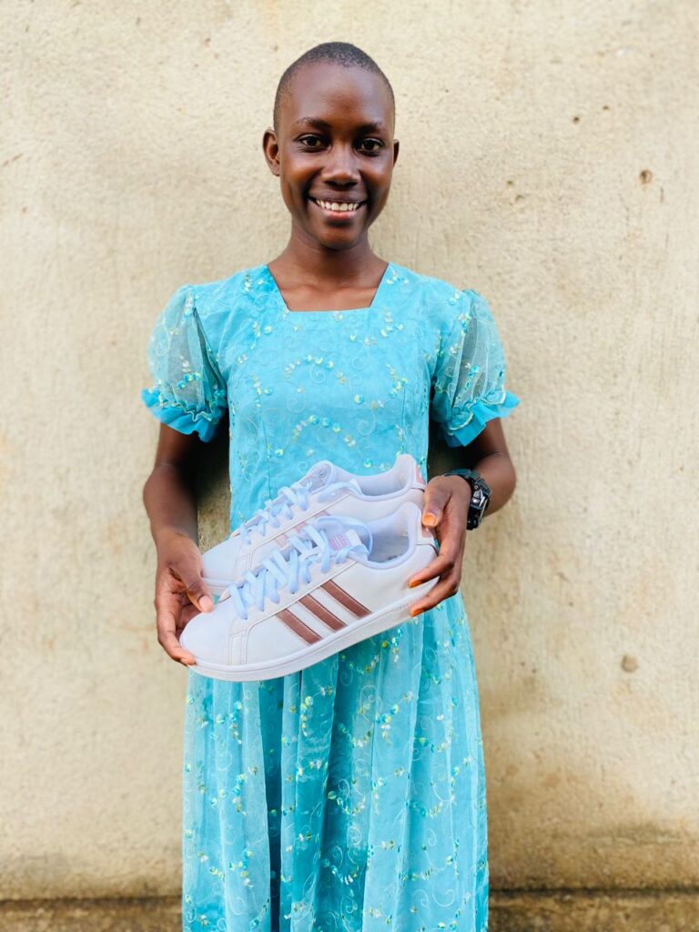 Girl smiling holding a pair of trainers