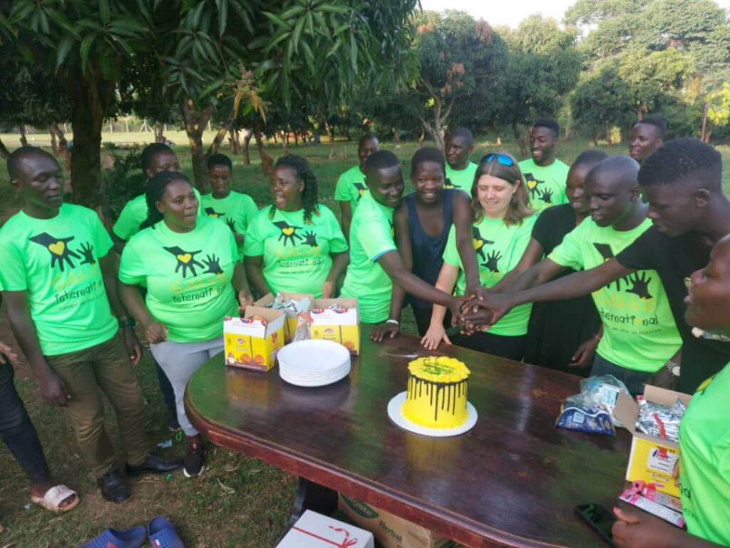 SALVE team members wearing SALVE branded t-shirts cutting a 15th birthday cake