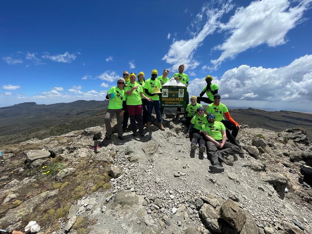 Group of people who climber Mount Elgon for SALVE with a birthday cake