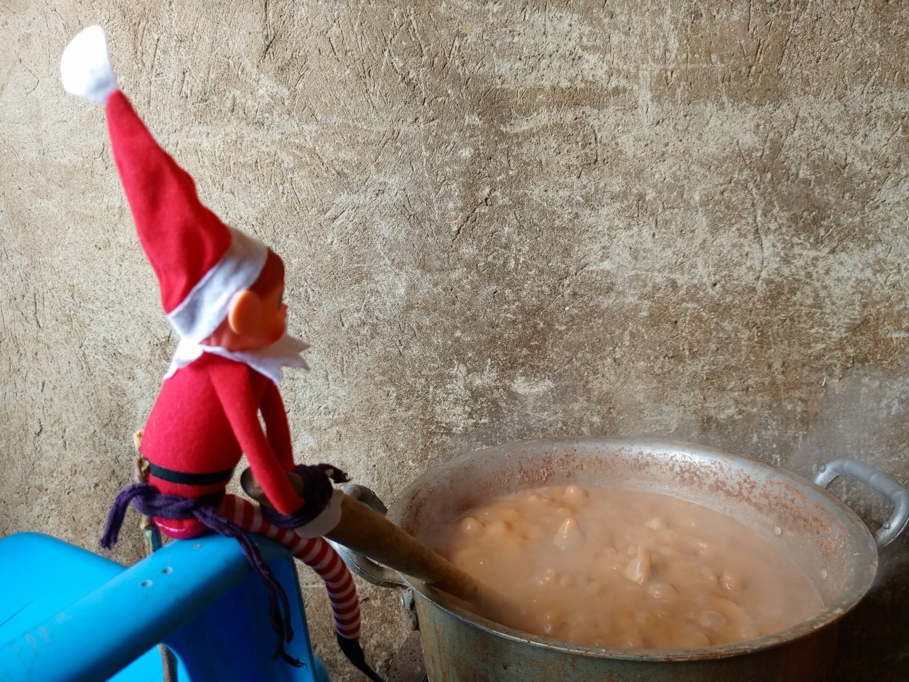 An elf toy mixing a bubbling pot of food
