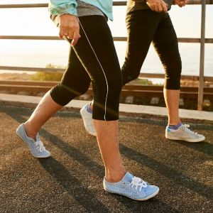 close up of two women walking, wearing sports leggings and trainers.
