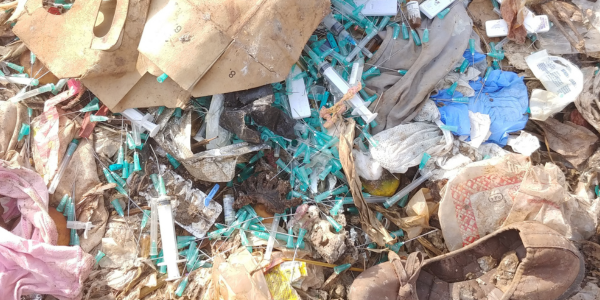 A close up picture of drug needles in a pile on a rubbish dump