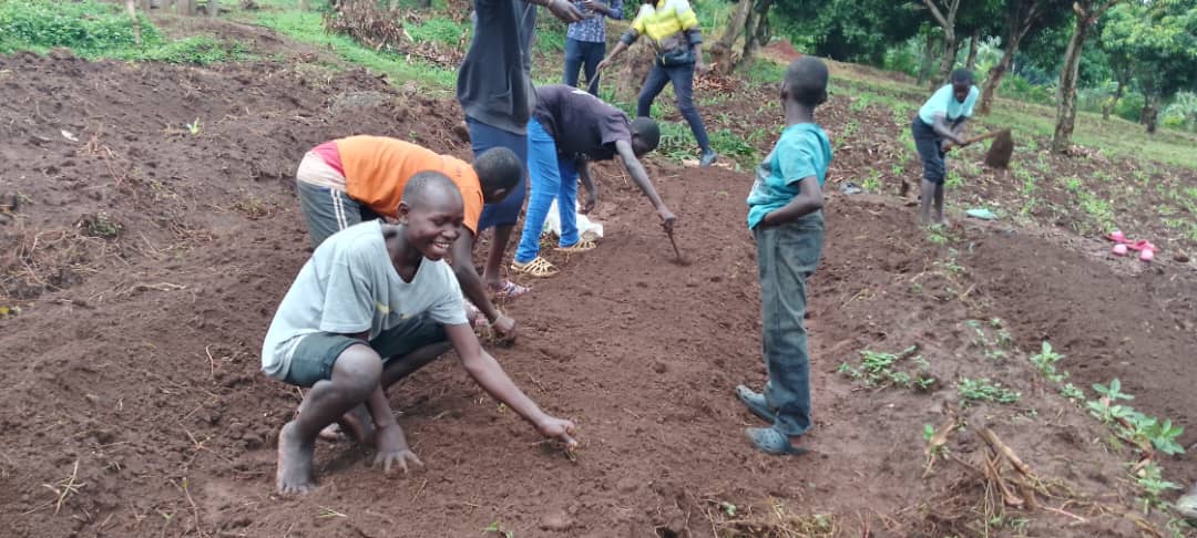 Children smiling and planting seeds in the earth