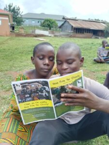 Two children reading News from the Streets